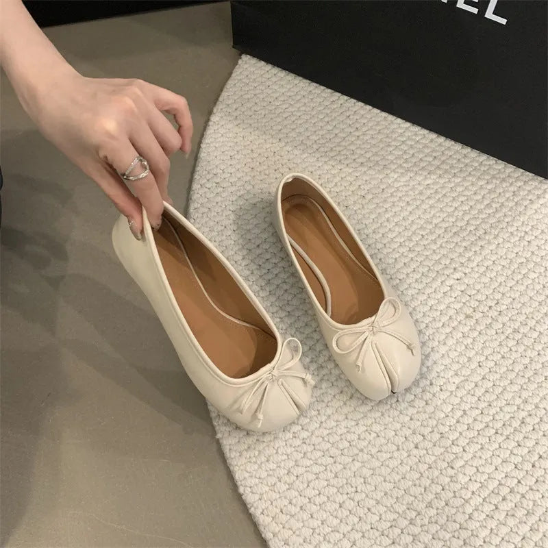 Women's flat split-toe pumps in beige with round toe and rubber sole.