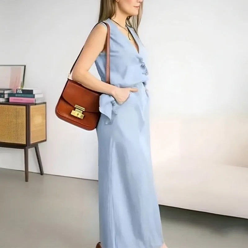 A woman modelling a blue sleeveless vest and matching long skirt from a casual two-piece suit.