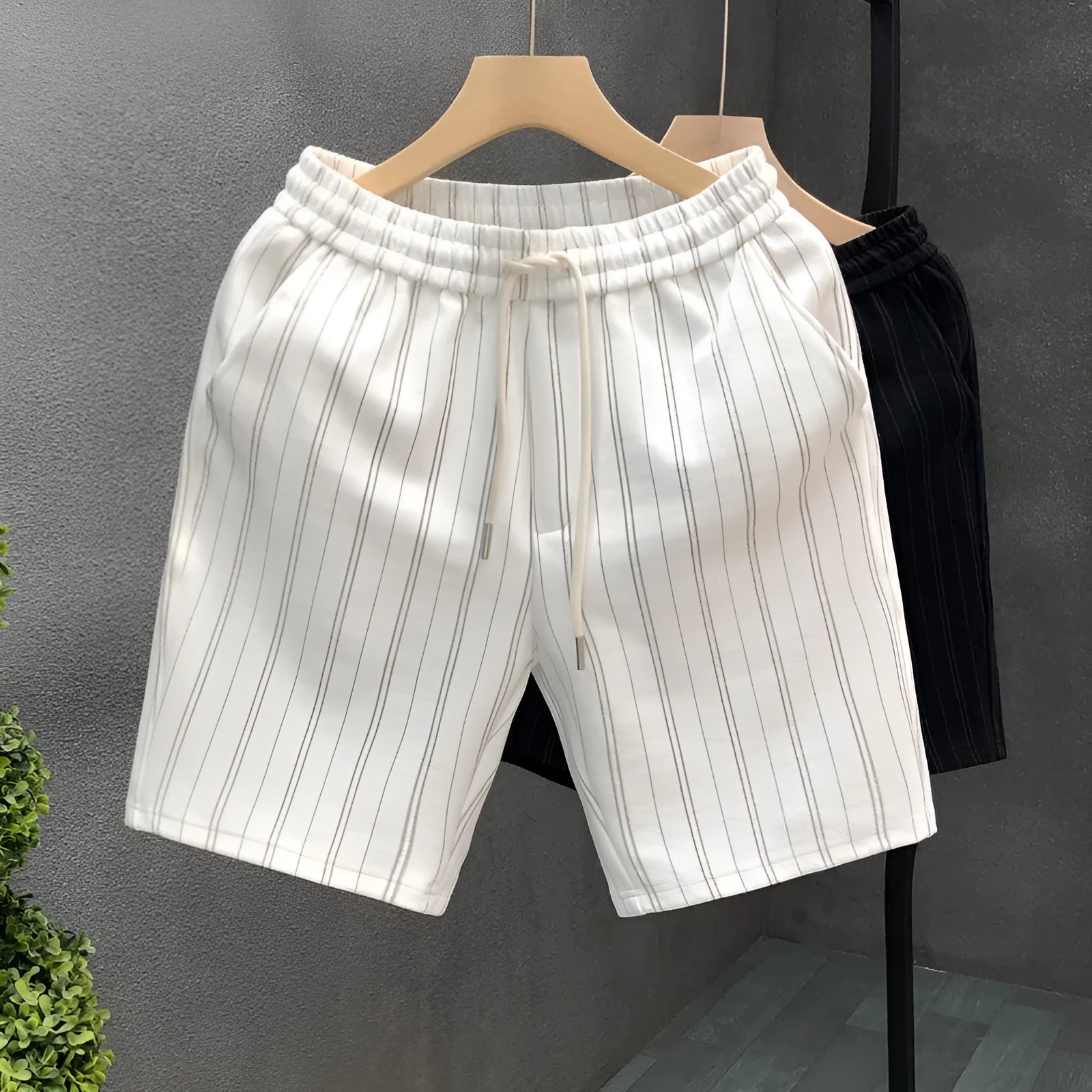 Men's black and white striped fleece-lined casual shorts showing straight leg and ankle band design.