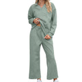Women's black knitted jacquard long sleeve sweater and elastic waist cropped pants suit on a hanger.