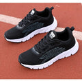 Women's black and white casual running sneakers with cross strap design and MD sole