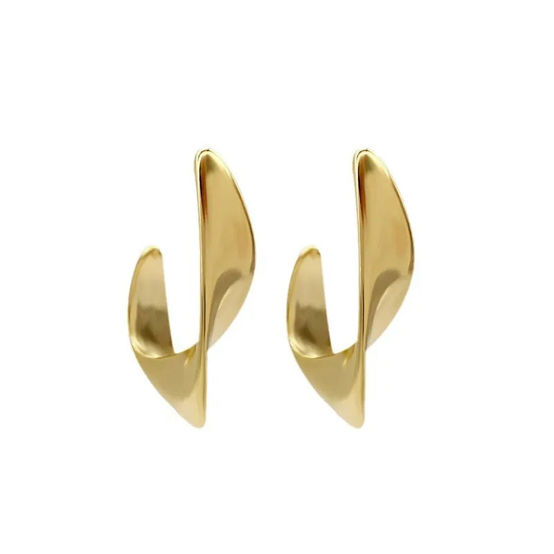 A pair of twisted geometric round metal earrings with a gold electroplated finish on a white background.