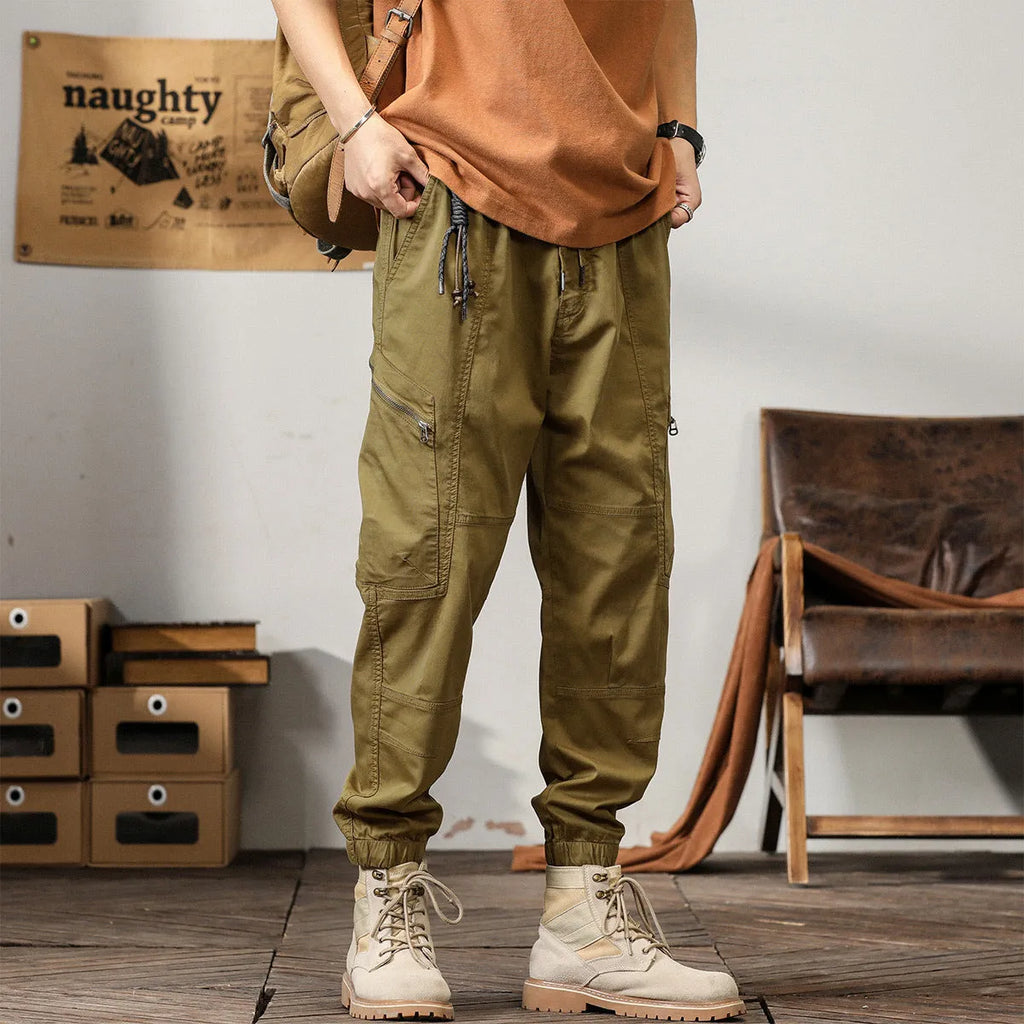 Men's khaki cotton harem pants with ankle bands and a loose, tapered fit.
