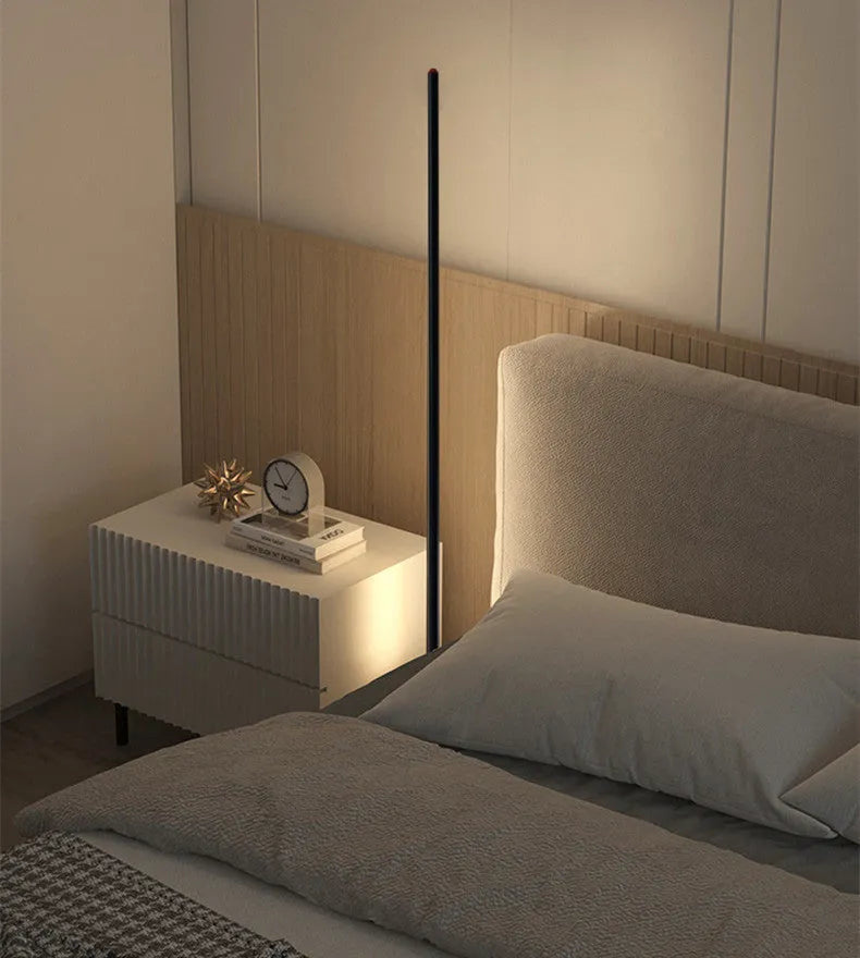 Slender vertical aluminium alloy LED floor lamp in a modern design next to a sofa.