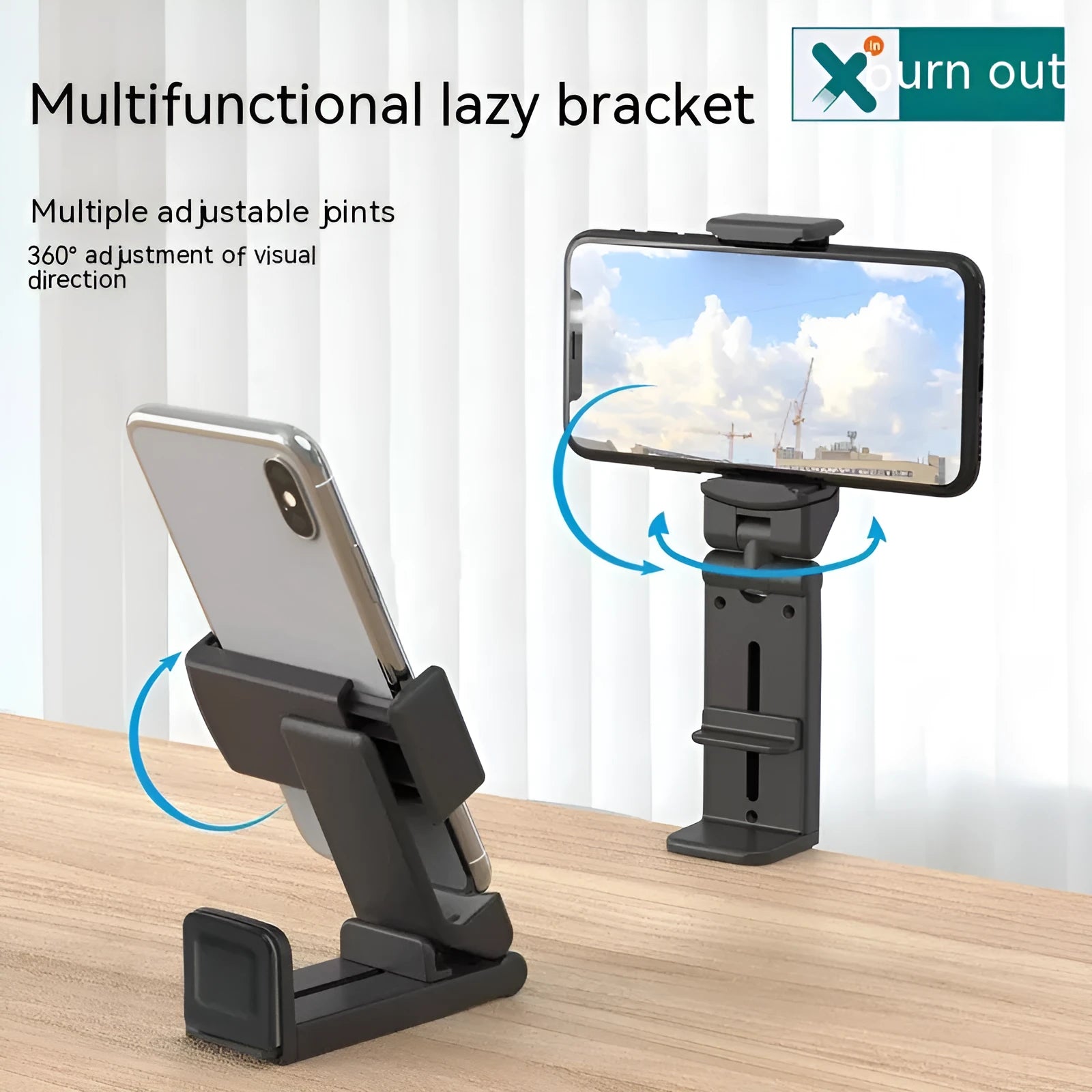 Black foldable ABS phone holder with 360-degree rotation on a desk next to a smartphone