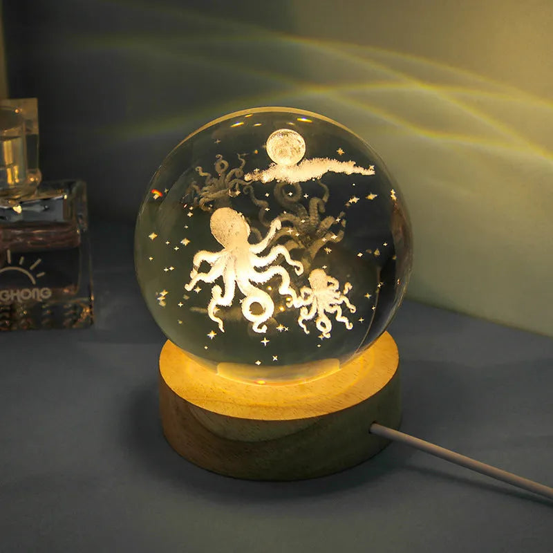 Transparent crystal ball night lamp with 3D carved jellyfish design, on a round base with USB cable.