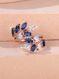 Adjustable copper leaf fashion ring with a central zircon stone on a model's hand, showing rose gold and platinum colour variants.