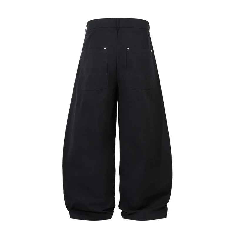 Men's black pleated wide-leg cotton trousers showing loose-fitting casual design