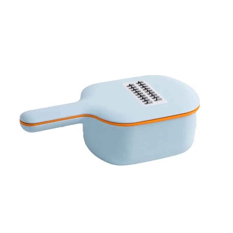 Dark blue scoop vegetable cutter with four stainless steel blades, hand guard and drain basket on a kitchen worktop