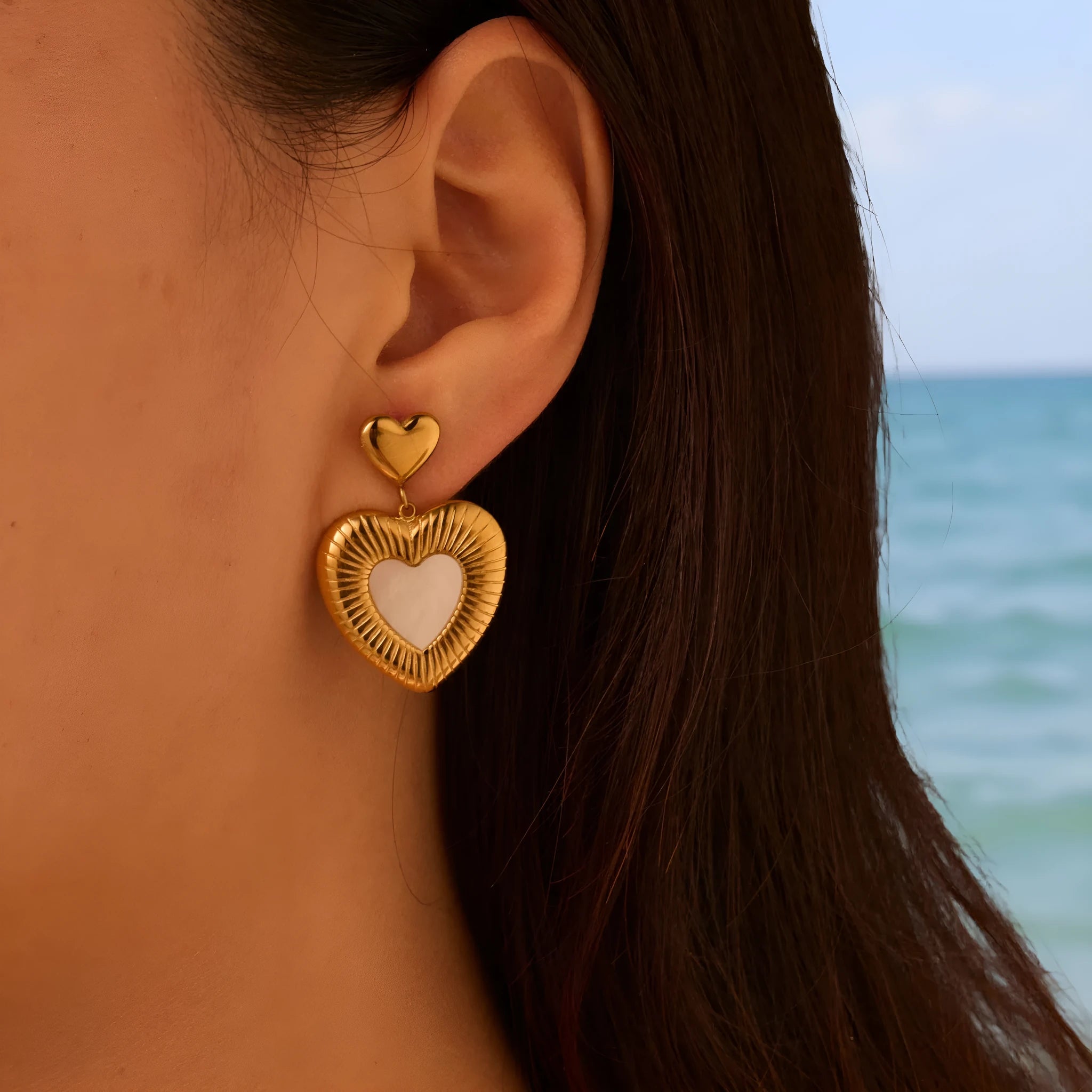 Gold electroplated heart-shaped stainless steel earrings with white fritillary detail