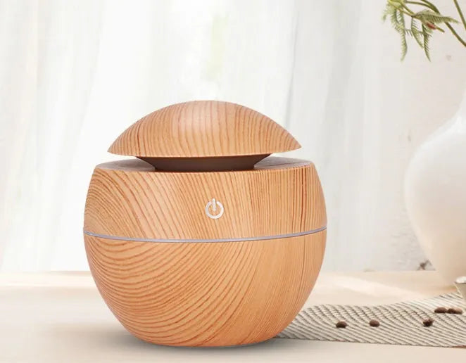USB aroma diffuser humidifier in light wood grain, 100x100x95mm, 130ml tank, coloured lights on desk