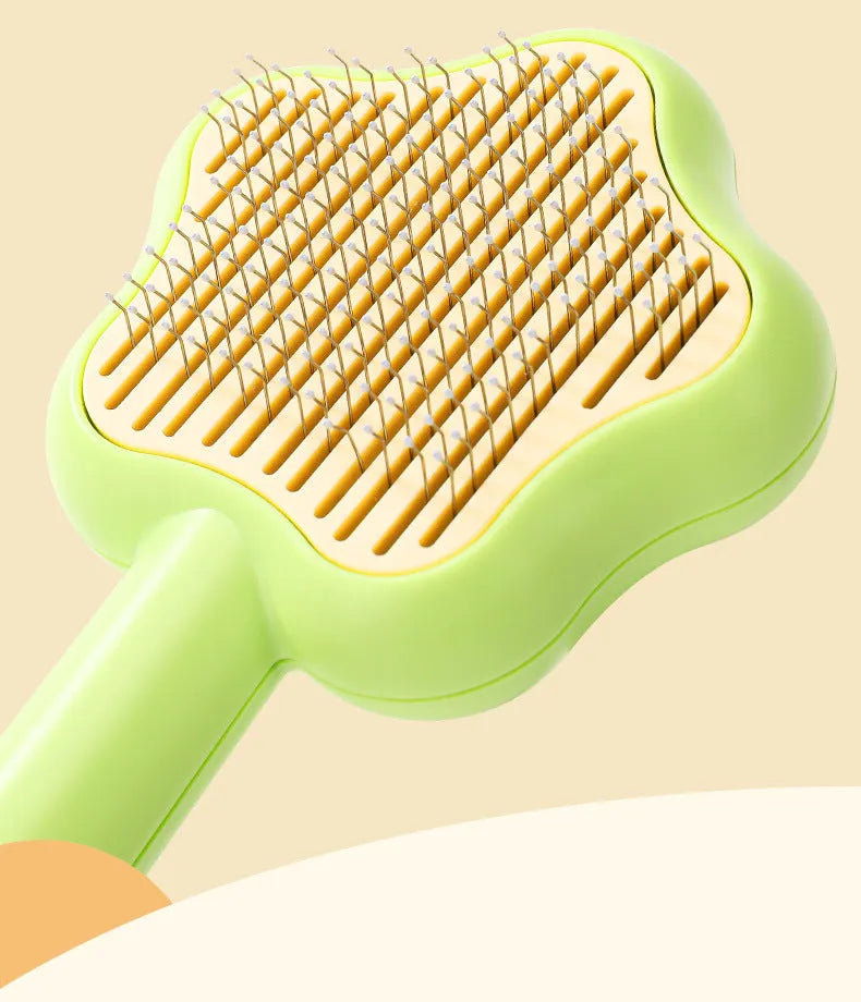 Green and yellow handled self-cleaning pet grooming comb with stainless steel needle bristles.