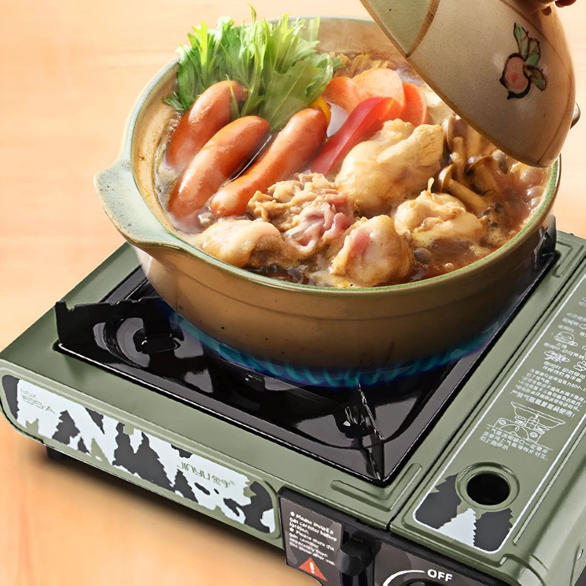 Portable gas stove in camouflage green with barbecue and hot pot function, suitcase, and stainless steel windshield