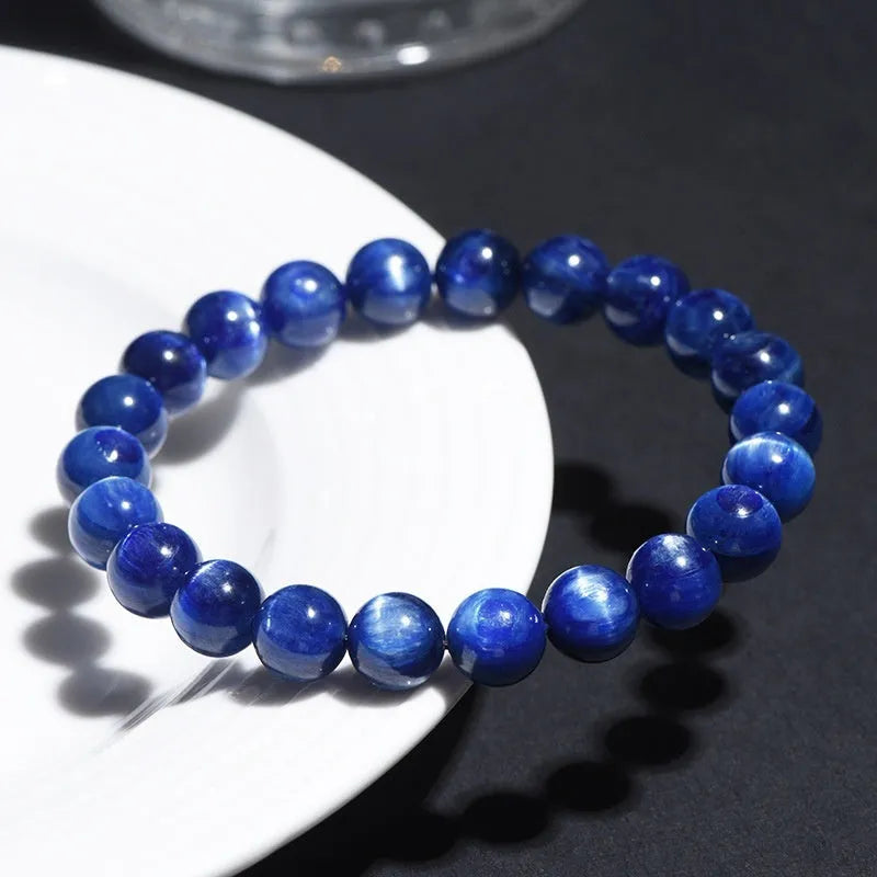 Blue crystal ball bracelet with geometric beads and a Ruyi charm on a white background.