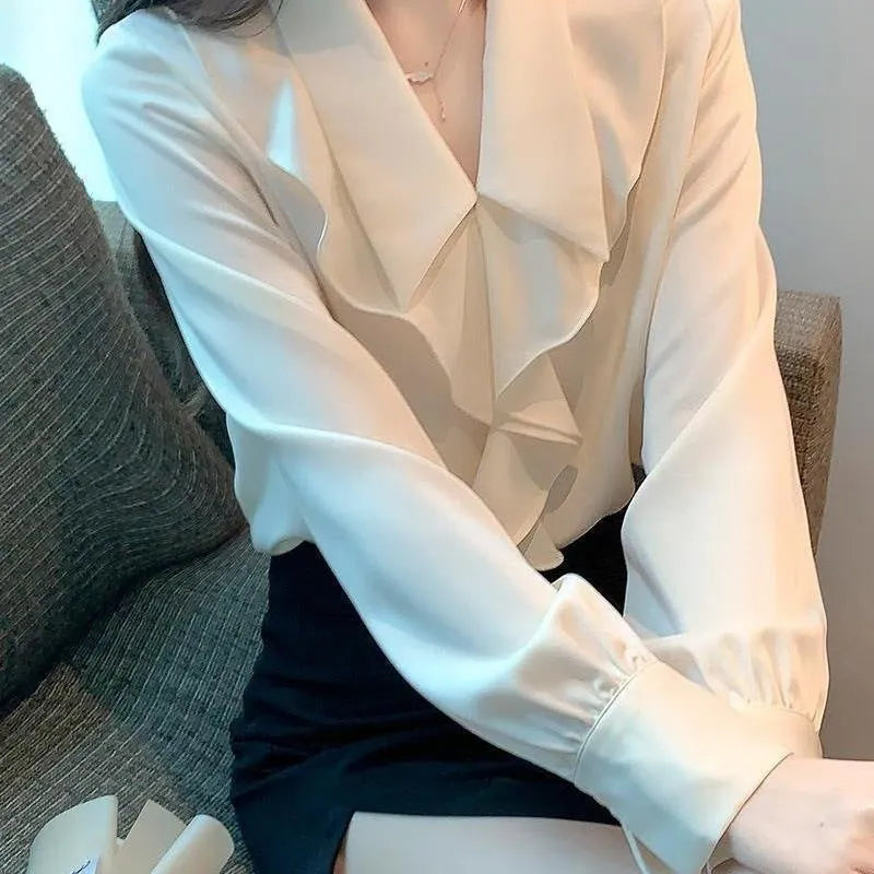 Ladies white chiffon blouse with long sleeves on a plain background
