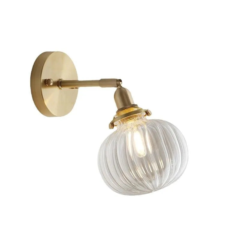 Close-up of a hand-blown water ripple glass wall lamp shade mounted on a white wall, showing its textured surface.