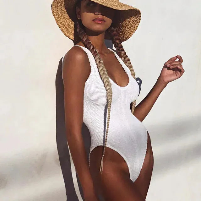 Women's solid colour one-piece swimsuit in seersucker fabric, shown in a sleeveless, backless design.