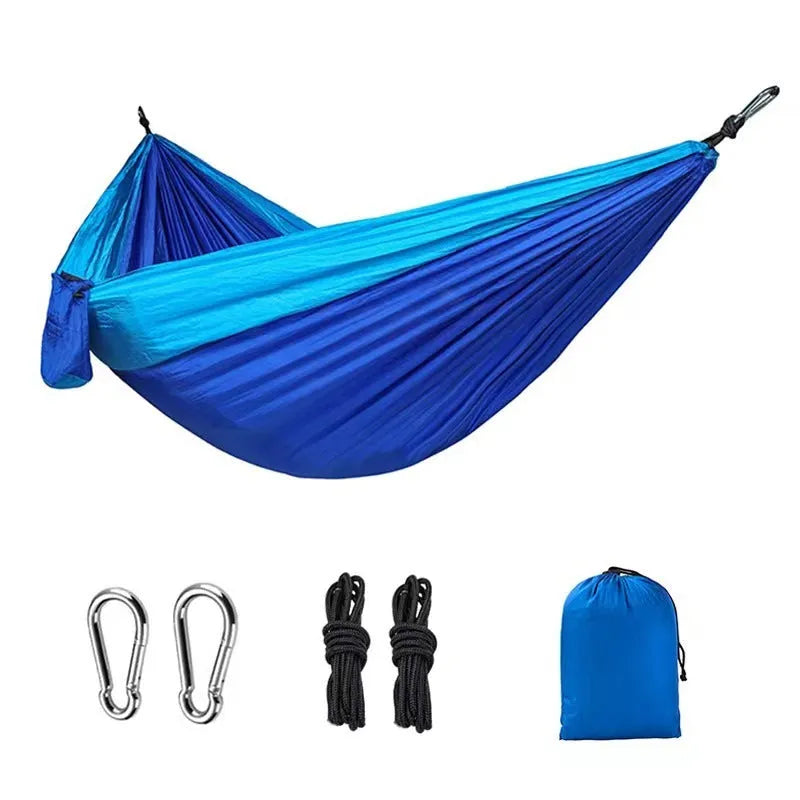 Sapphire blue parachute nylon camping hammock hung between two trees, showing its full 270cm length.