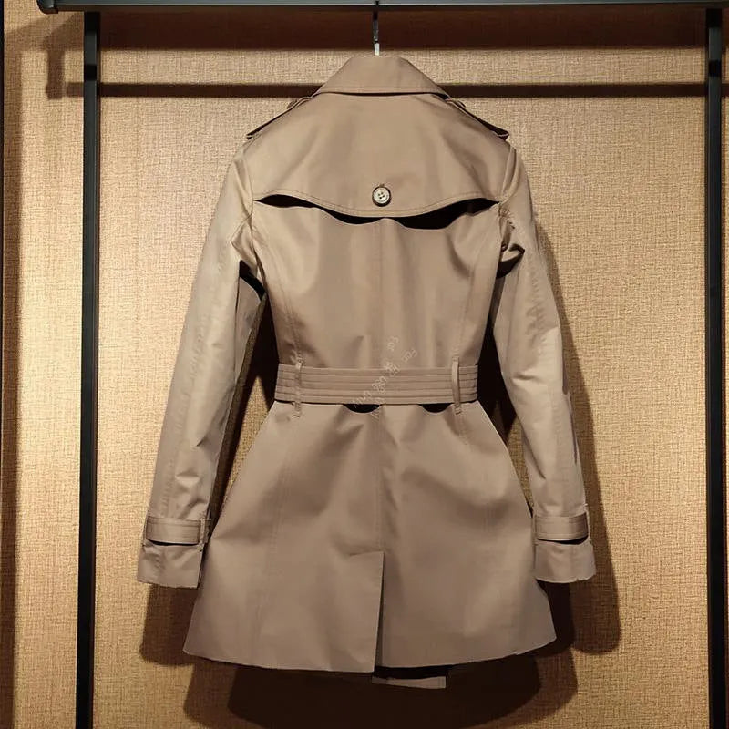 Khaki coloured women's double-breasted trench coat with flight sleeves on a hanger.