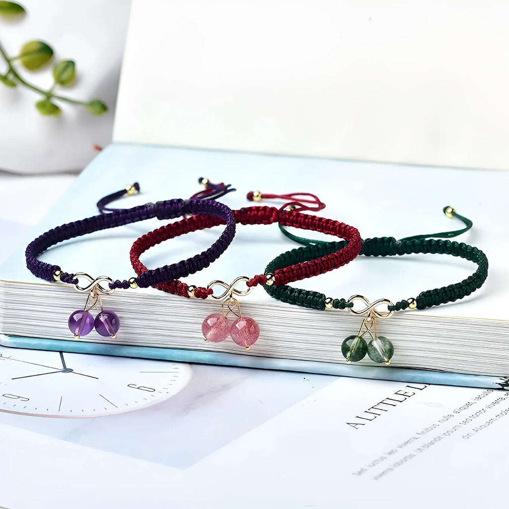 Women's natural strawberry quartz bracelet with a detailed cherry-shaped crystal charm.