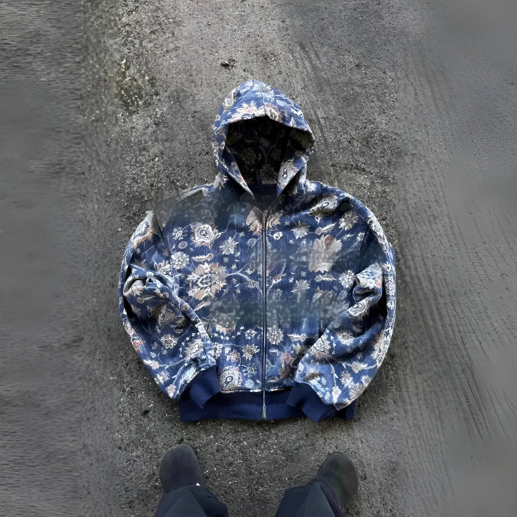 Man wearing a loose-fitting blue hooded zip-up coat with digital printing.
