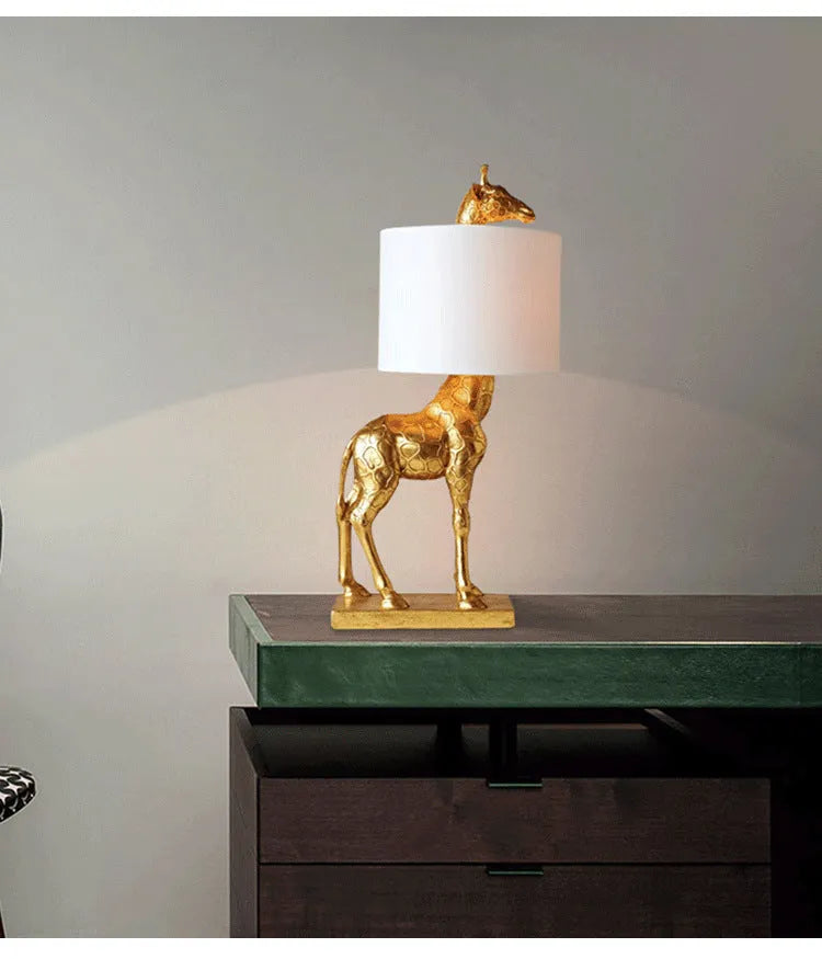 Giraffe table lamp with resin base and cloth shade, 66cm high, in white finish on a bedside table