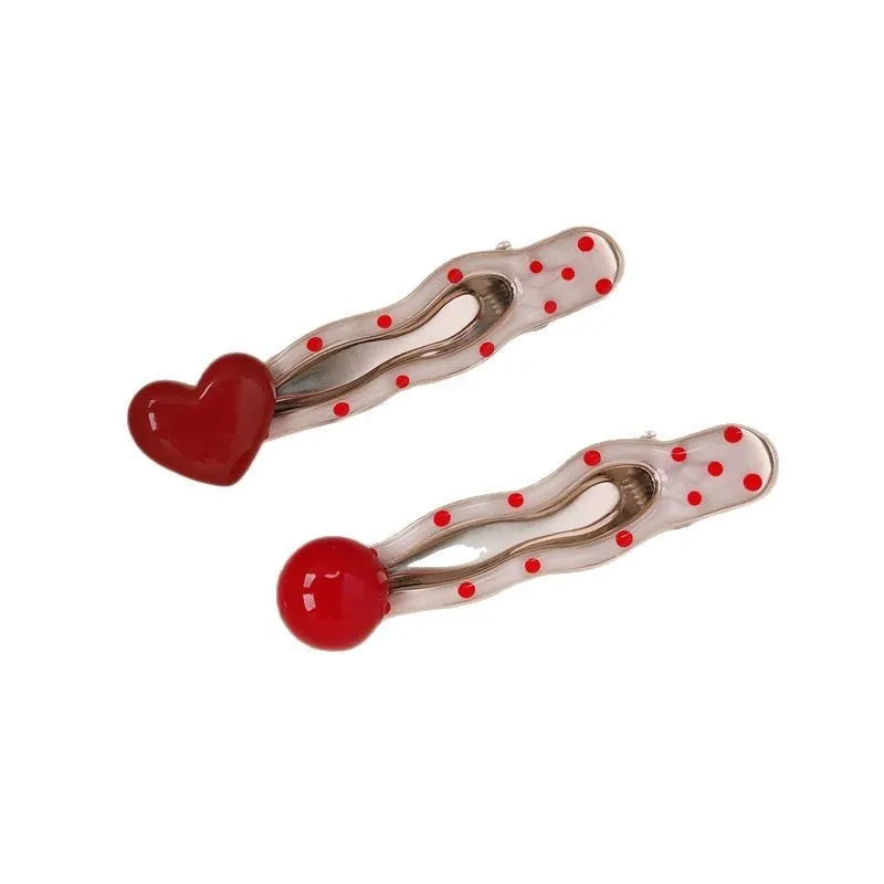 Red stereo love heart-shaped hairpin with French retro dots and willow leaf decoration on a white background.