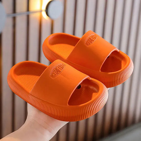 Bright coloured children's EVA slippers with textured sole, shown in blue, green, orange, pink, and yellow.