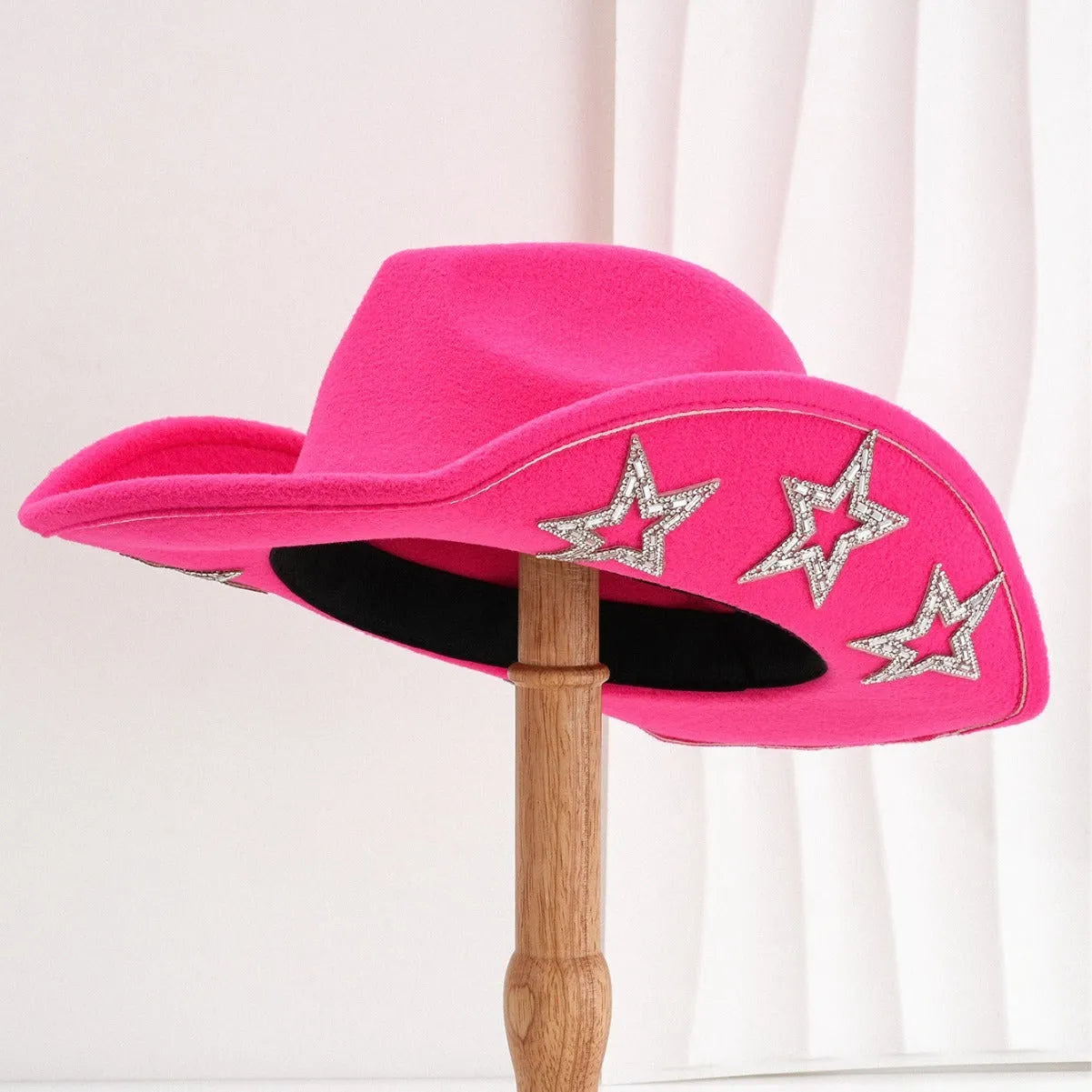 Beige woolen felt Western top hat with a conical crown and a decorative hexagonal star on the front.