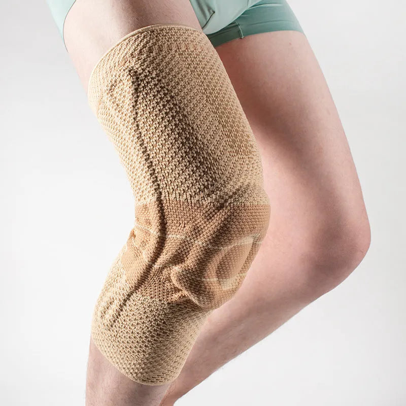 Adult sports kneecap or knee pad in black and blue colour, made from nylon spandex, shown on a knee.