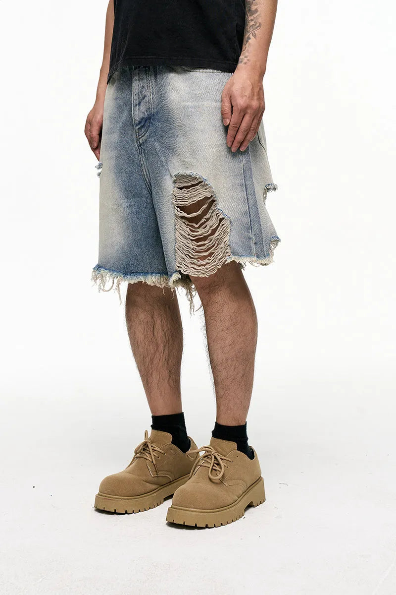 Light blue washed denim shorts for men with a baggy fit and mid waist, shown on a hanger.