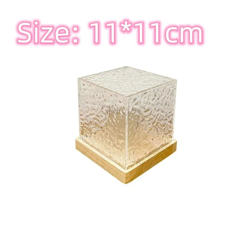 Modern geometric crystal table lamp projecting blue water ripple light pattern on a wall.