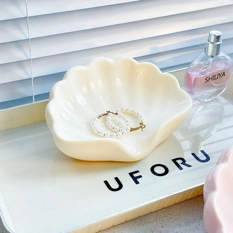 White plastic shell-shaped soap dish on bathroom countertop