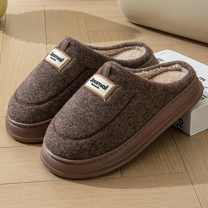 Men's brown and grey suede slippers with a thick sole on a plain background