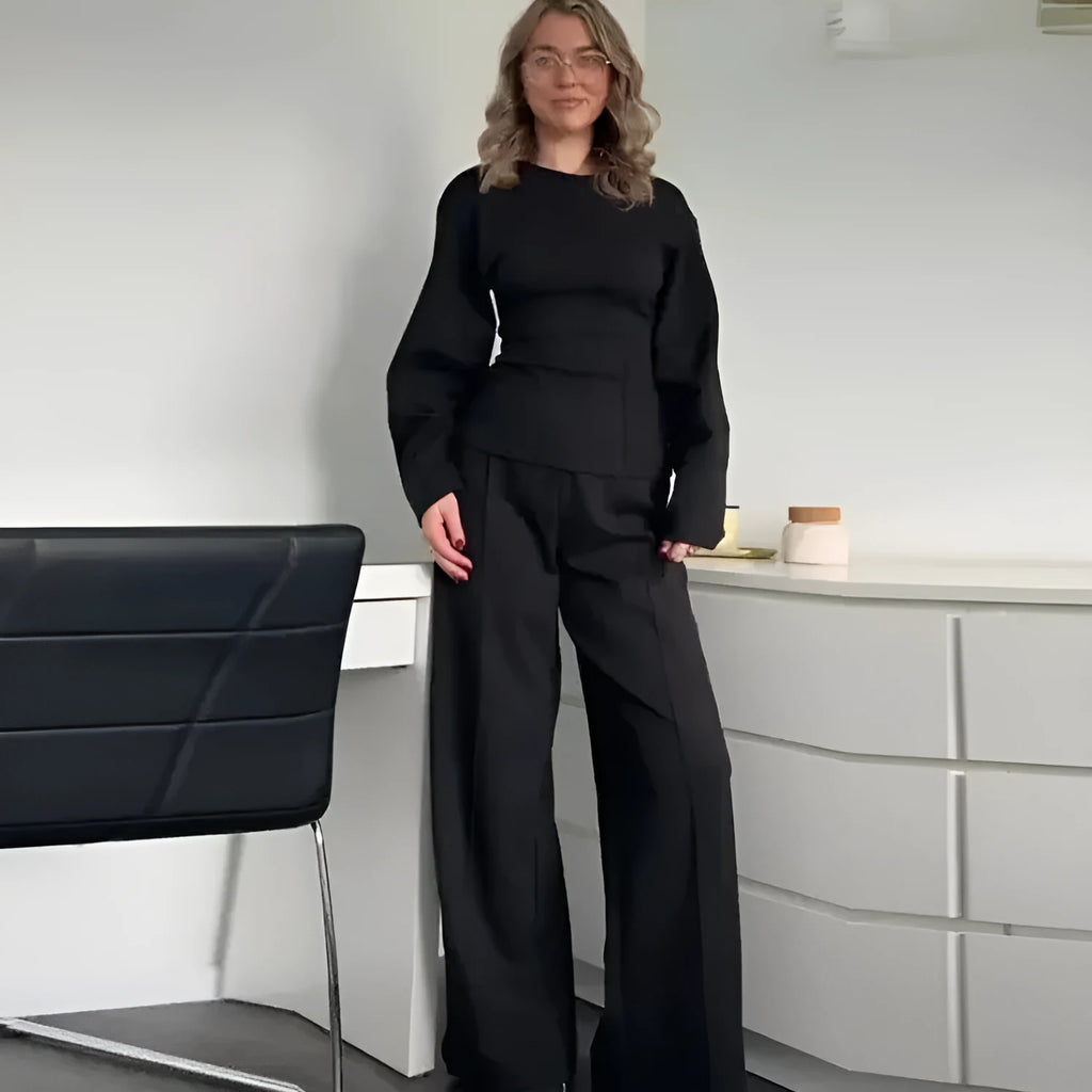 Women's black polyester fleece two-piece suit with long sleeve top and wide-leg trousers on a hanger.