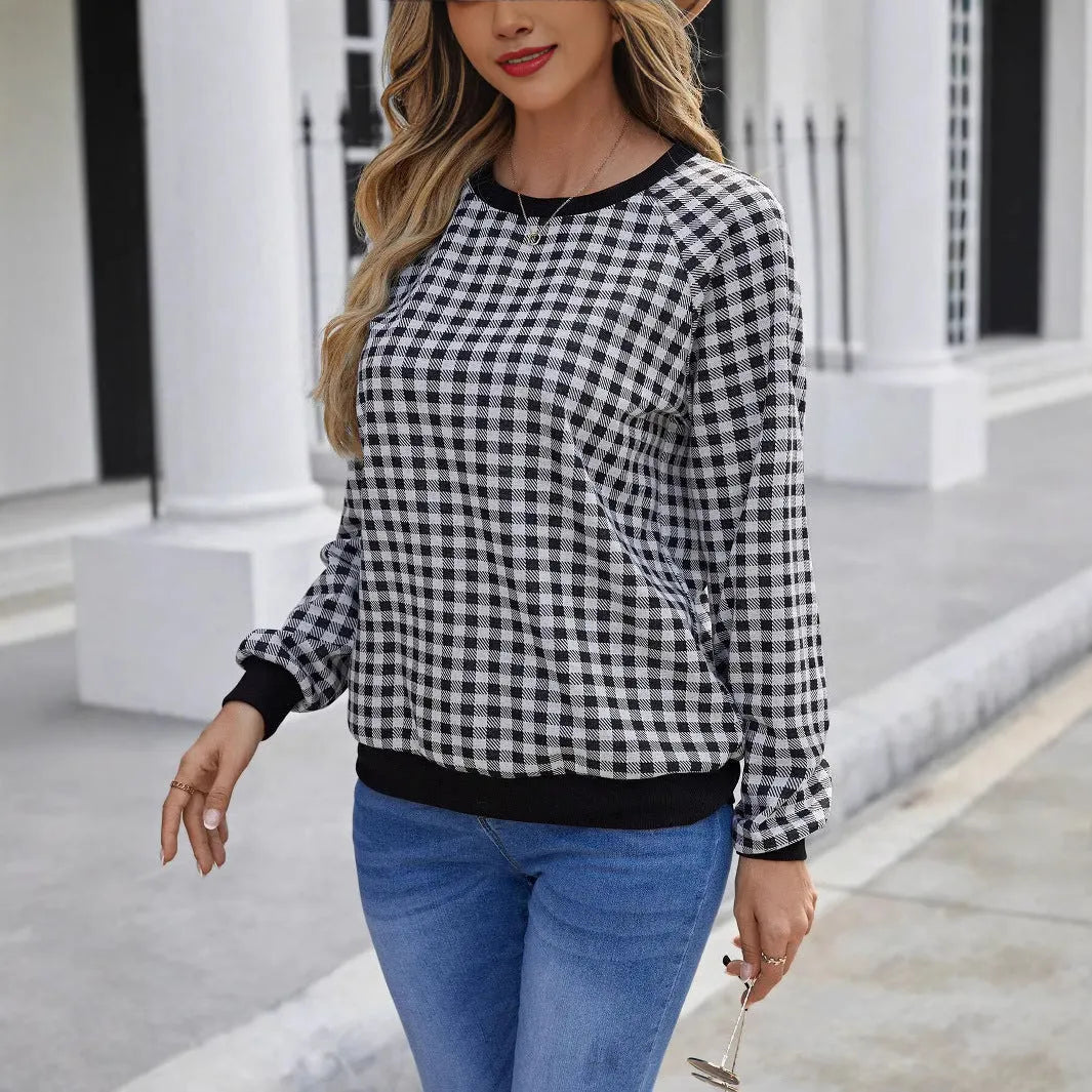 Black and white plaid print long sleeve pullover sweater for men on a neutral background.