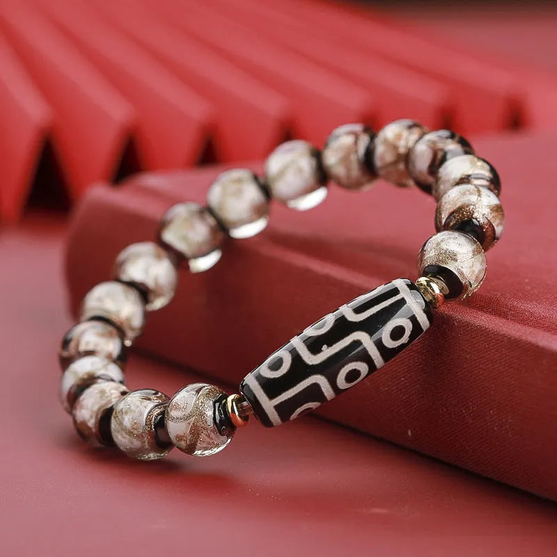 Close-up of a handcrafted coloured glaze bracelet with multi-colour lucky beads and auspicious Chinese patterns.