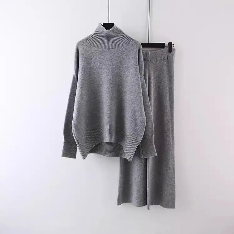 Women's beige acrylic knit long-sleeve sweater and matching wide-leg trousers set on a hanger.