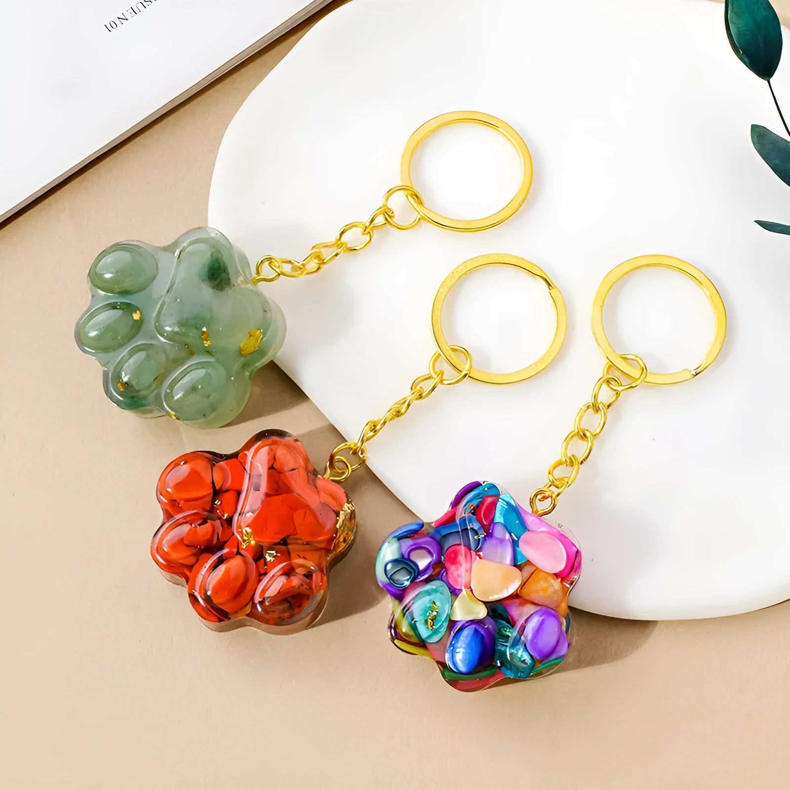 Natural crystal cat's paw shape pendant on a metal keyring, showing example of polished stone like turquoise or amethyst.