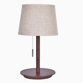 Walnut coloured solid wood bedside lamp with a white cloth lampshade and a black cable switch.