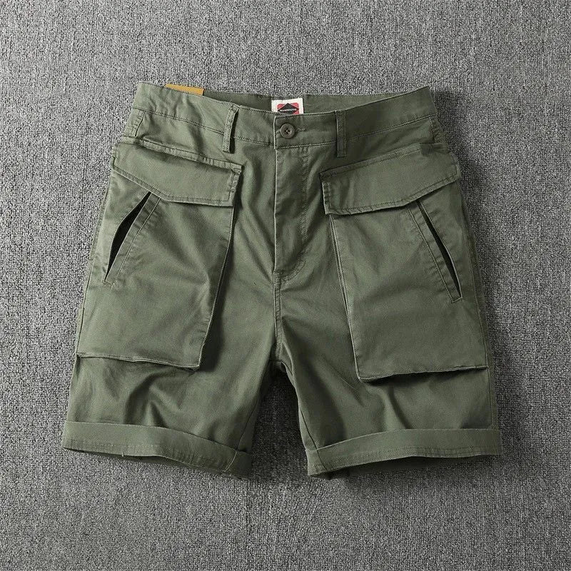 Men's straight-leg cotton cargo shorts in khaki with multiple pockets, shown on a model for summer street style.