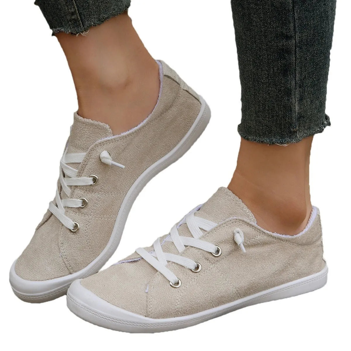 Women's creamy white casual low-top sneakers with fabric upper and rubber sole on a neutral background.