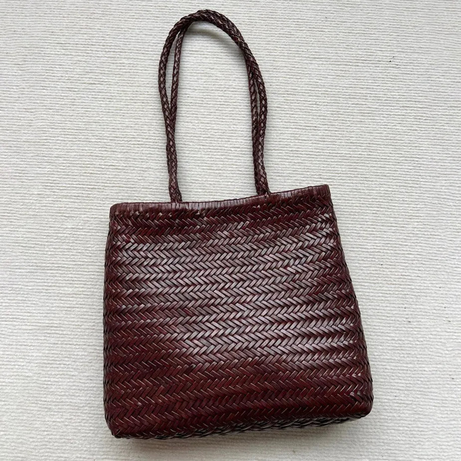Brown vintage woven leather tote bag with a three-dimensional front pocket.