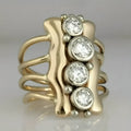 Gold electroplated zinc alloy retro creative fashion ring for women on a plain background