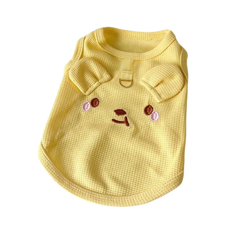 Yellow waffle-knit dog vest on a small dog, showing the textured fabric and casual fit.