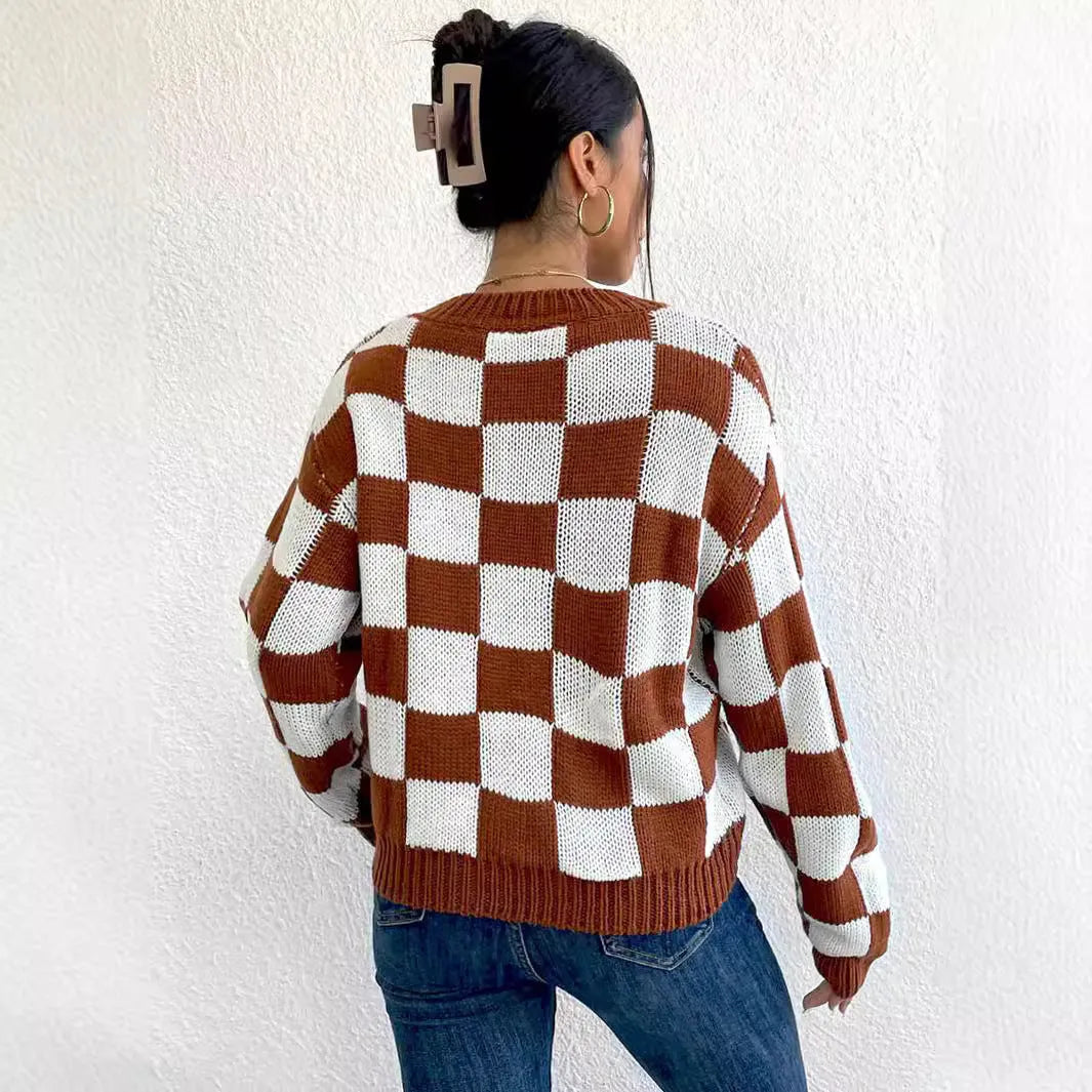 Dark brown plaid loose fit acrylic pullover sweater with long sleeves on a hanger.