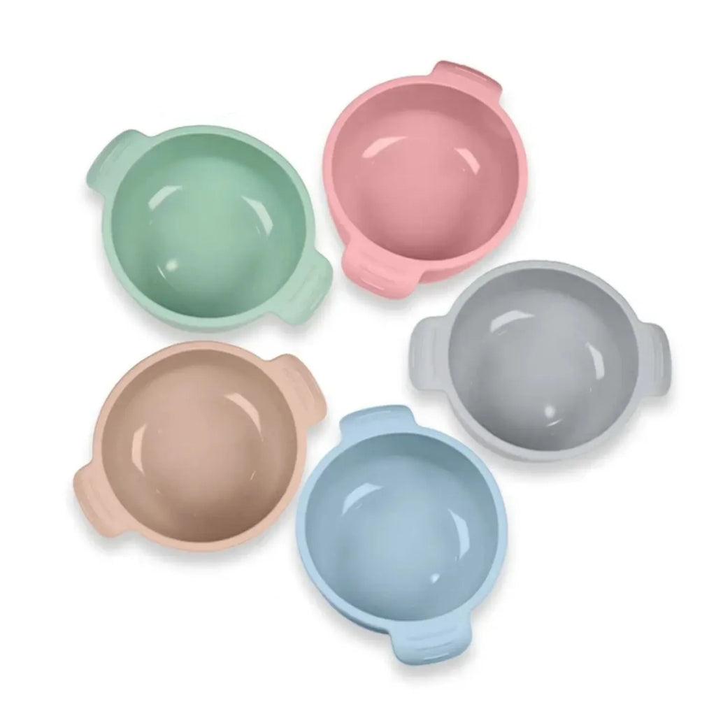 Blue silicone pet bowl for dogs and cats with a non-slip suction cup base on a hardwood floor.