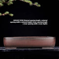 Large rectangular handmade antique purple clay flower pot on a table.