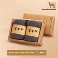 Pair of thick grey wool socks with a reinforced merino wool midsole for winter, presented in a box.