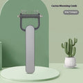 Green and grey dog grooming unknotting comb with stainless steel pins on a plastic handle.